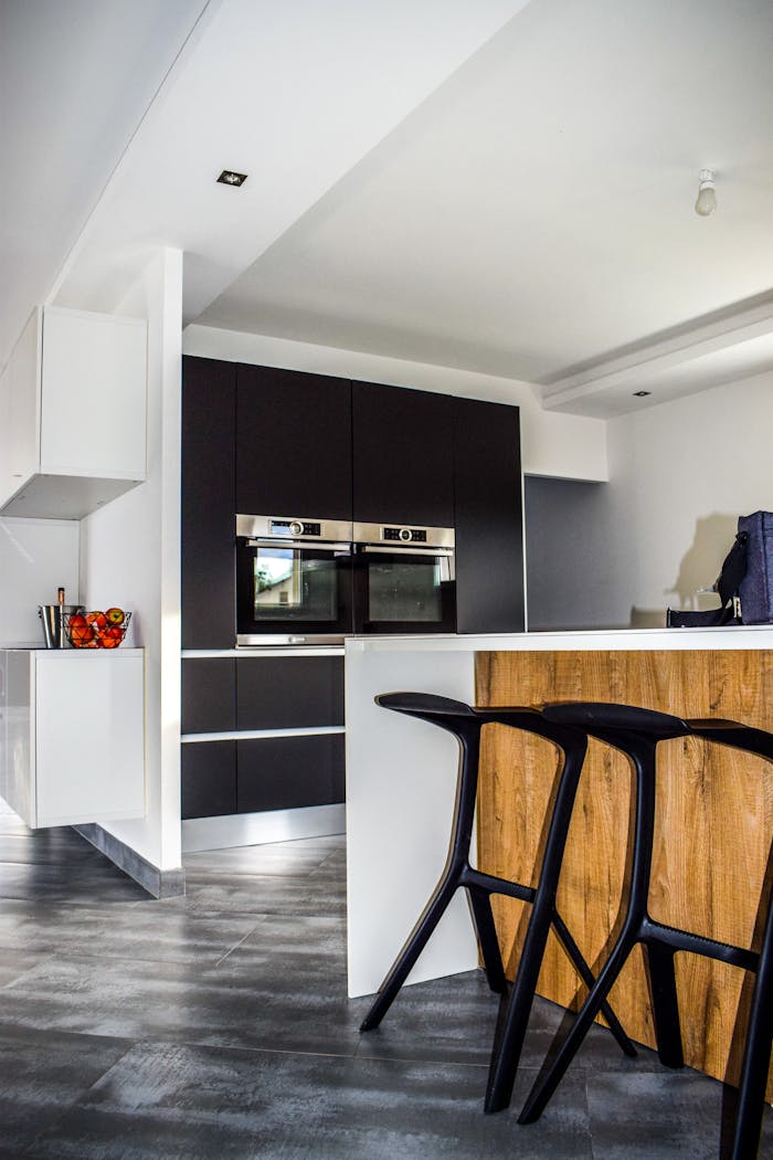 A contemporary kitchen featuring sleek cabinetry and elegant bar stools in a minimalist design.